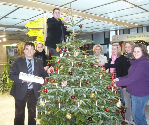 Bürgermeister Werner Arndt mit Mitgliedern der Jugendvertretung und Auszubildenden beim Schmücken des Weihnachtsbaumes im Rathaus.