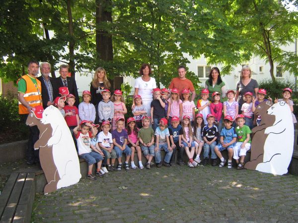 Gruppenbild mit Erstklässlern und ihren neuen roten Sicherheitskappen