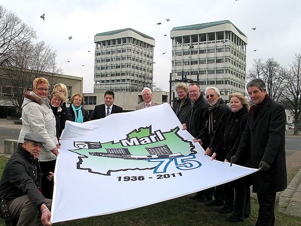 Bürgermeister Werner Arndt und Ratsvertreter mit der offiziellen Fahne zum Stadtjubiläum