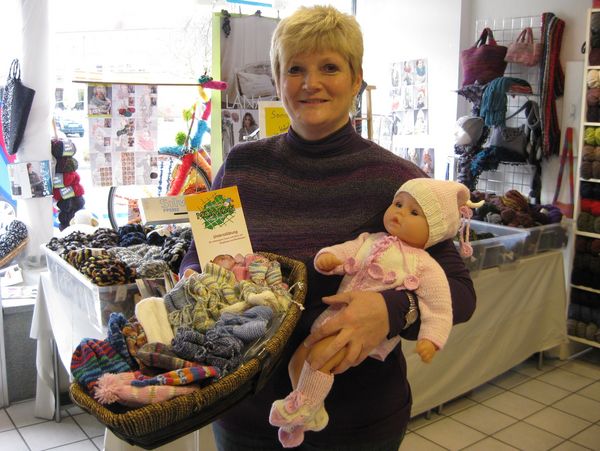 Inhaberin Marion Schümchen präsentiert die Stricksachen für die Begrüßungsbesuche in den Familien