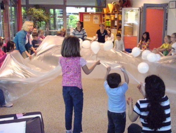 Kinder spielen mit einem Schwungtuch